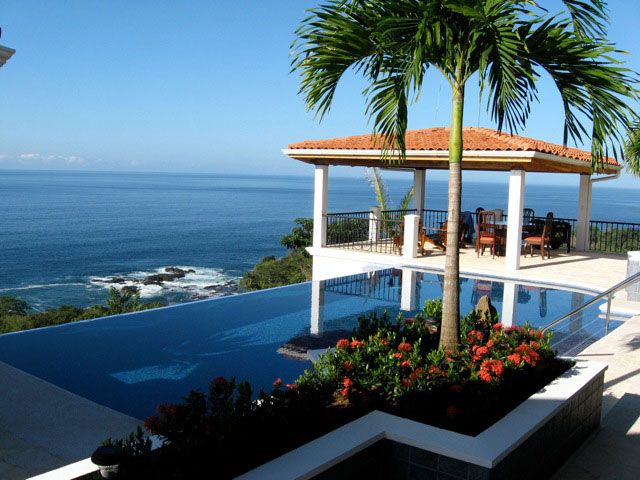 "Luxurious ocean-view beach house in Costa Rica at sunset, ideal for US and Canadian expats seeking affordable paradise living"